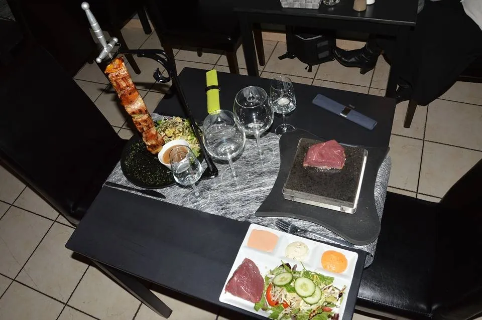 Une épée dressée sur la table, à côté d’un carpaccio et de ses condiments